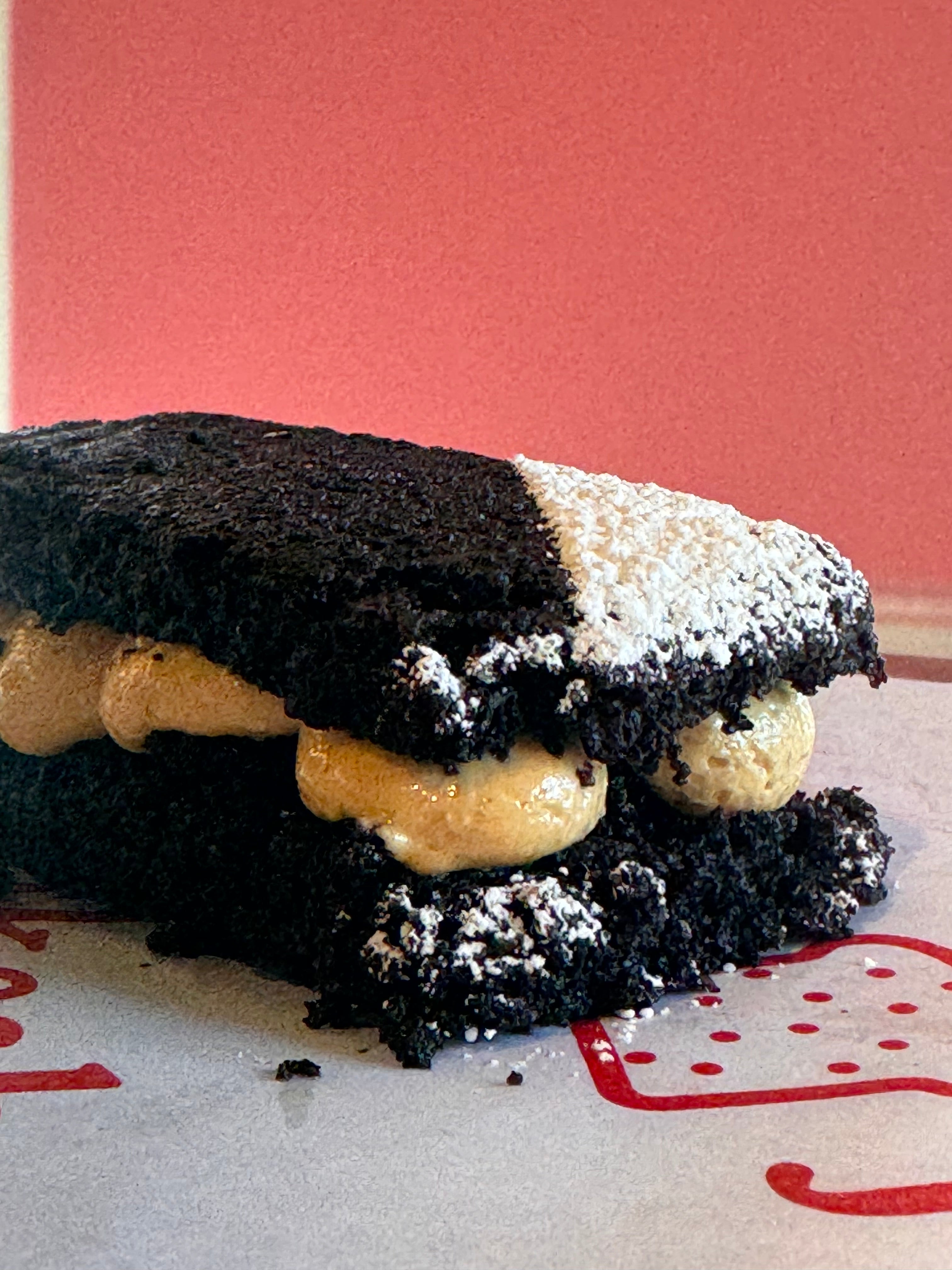 Close-up of a dessert with black and white layers on a red and white background
