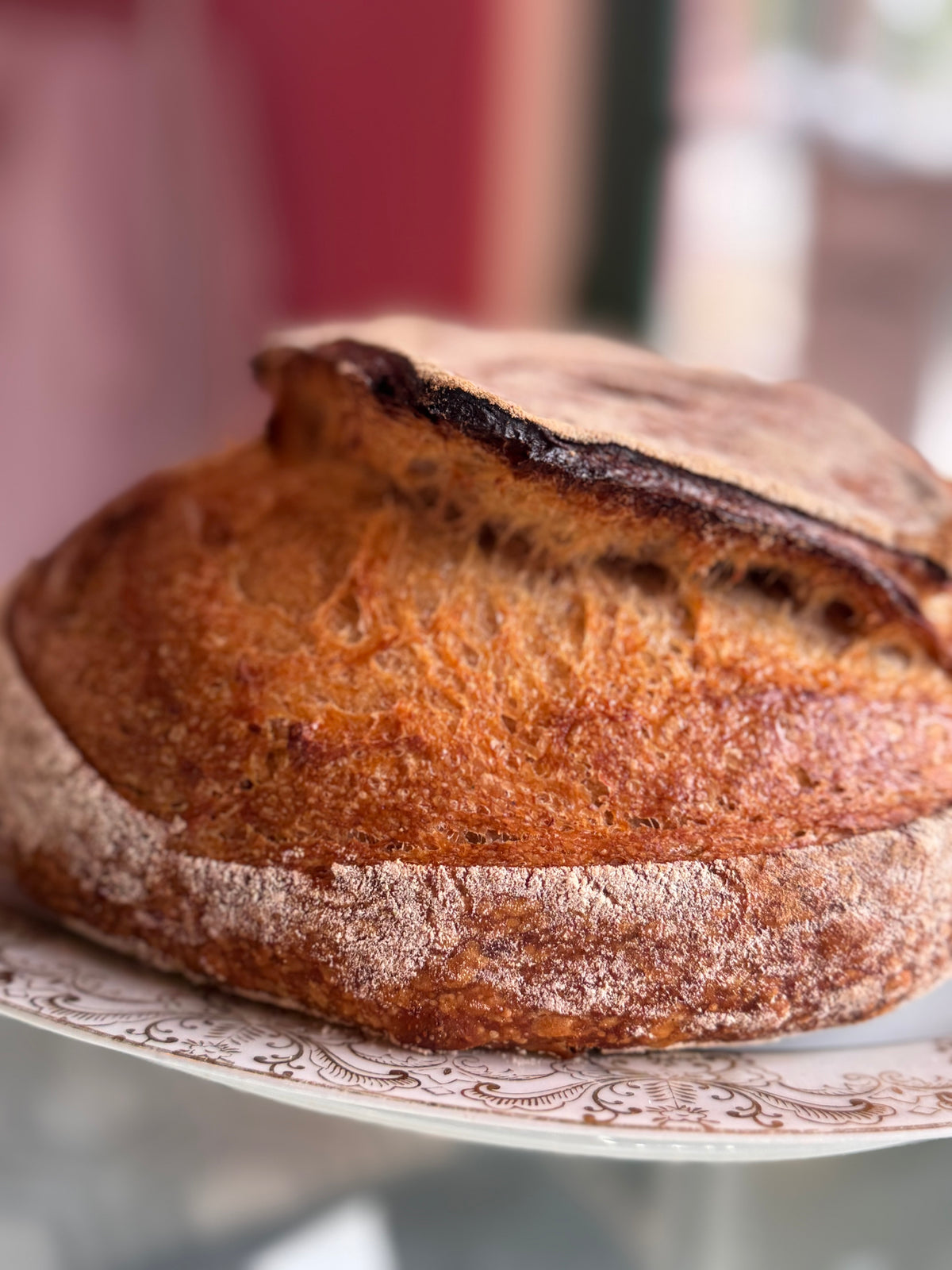 Loaf of bread on a decorative plate with a blurred background