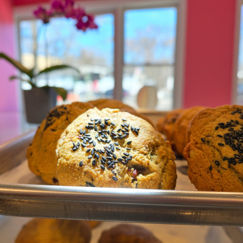 Cookies with sesame seeds on a metal rack with a blurred indoor background
